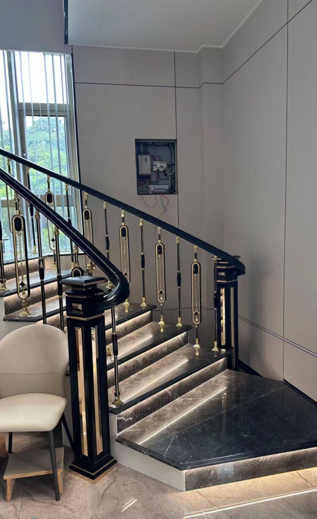 Klassische Villa-Treppe mit ornamentalen schwarz-gold Balustern und Holz-Handlauf